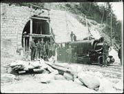 Arbeiter posieren neben einer Lokomotive vor dem Südportal des Bruggwaldtunnels. (Bild: PD/Staatsarchiv St. Gallen)