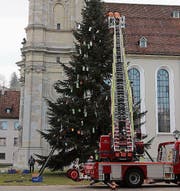 Der grosse Christbaum auf dem Klosterplatz muss weg: Die Feuerwehr sammelt am Montag den Schmuck ein. Und was vom Stamm der Tanne bleibt, nämlich zwei Meter lange Holzstücke, wird am Dienstag verladen.