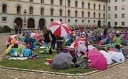 Schule einmal anders: Mit Badetuch und Regenschirm auf dem Klosterplatz Znüni essen. (Bild: Manuel Roth)