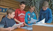 Amtsberichte adressieren, nach Strassen und Hausnummern sortieren und ausliefern. Valerio Spirig, Julian Benz, Dominik Seitz und Timo Mörgeli im Schulhaus Kirchenfeld fanden die Aufgabe wichtig und spannend. (Bild: René Schneider)
