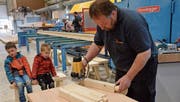 Interessiert beobachten die beiden Knaben, wie ein Mitarbeiter der Zimmerei in Schwarzenbach die Sitzbänkli für die Besucher anfertigt. (Bilder: Christoph Heer)