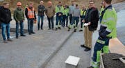 Im Beisein von rund 40 aller am Neubau beteiligten Vertreter versenkt RWT-Geschäftsführer Andreas Jossi, zweiter von rechts, die Zeitkapsel (am Boden stehend) in das Fundament des Neubaus an der neuen Industriestrasse in Bazenheid. (Bilder: Beat Lanzendorfer)