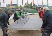 Immer wieder müssen die Männer vom Betriebsdienst anpacken, bis das Podest für die Ehrengäste am rechten Ort steht.