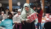 Freudestrahlend nehmen die Menschen im K-Treff die Geschenke entgegen, die Wittenbacher und Mörschwiler verpackt haben. (Bild: Ralph Ribi)