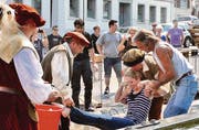 Da gibt's kein Entrinnen: Unsanft werden die «Opfer» an Händen und Füssen gepackt, mit Wasser überschüttet und in den Brunnen geworfen.