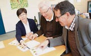 Die Gemeindepräsidenten Imelda Stadler, Karl Brändle und Toni Hässig diskutieren ältere Wappenentwürfe. (Bild: Martin Knoepfel)