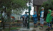 Ein paar mutige Kinder nehmen eine Dusche unter dem Wasserstrahl der neuen Wasserpumpe. (Bilder: Gianni Amstutz)