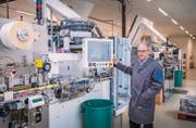 Permapack-Chef Thomas Hansmann und die neue Anlage zur Tubenproduktion. (Bild: Urs Bucher)