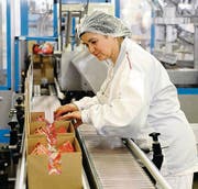 Eine Arbeiterin verpackt Glaces in Kartons.