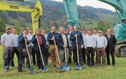 Martin, Wendel, Christof, Sepp und Andreas Giezendanner (mit Schaufeln, von links) vollziehen mit den Mitarbeitern und dem Vertreter der Bank den Spatenstich für die neue Werkhalle. (Bild: PD)