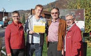Lucia Probst, Arthur Meier und Alfred Knüsel vom Verein Zuger Wanderwege überreichen Reto Scherrer das Schild. (Bild: PD)