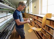 Erwin Tobler mit einer Lochkarte in seiner Werkhalle in Götighofen. Hier sticken historische Maschinen künftige Kunstwerke. (Bild: Helio Hickl)