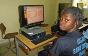 Eine Schülerin in einer Schule im senegalesischen Thiès vor einem Computer mit St. Galler Bildschirm. (Bild: pd)