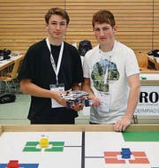 Kauê Manser und Remo Tobler mit ihrem Roboter vor dem Spielfeld. (Bild: pd)