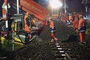 SBB-Mitarbeiter bauen nachts ein neues Schotterbett und ein neues Gleis am Bahnübergang ein. (Bild: Nana do Carmo (Berlingen, 7. Oktober 2014))