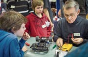 Am Repair-Café im Quartiertreff Talbach: Ein Helfer repariert das Rennauto der beiden Buben. (Bild: Andrea Stalder (18. Februar 2017))