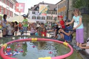 Mit und ohne elterliche Hilfe: Kinder versuchen sich in der Frauenfelder Altstadt im Böötli-Fischen. (Bild: Christof Lampart)