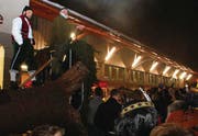 Die Versteigerung lockt viel Volk an. Letztlich kann der Förster (im grünen Gewand) den Stamm des Herisauer Blochs für 3500 Franken verkaufen. (Bild: bei)