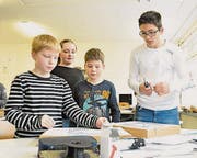 Die Schüler testen ihre selbstgemachte Karte mit den Lämpchen. (Bild: Lukas Hutter)