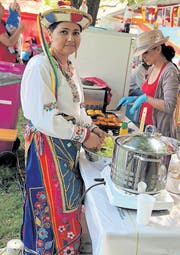 Eine Trachtenfrau aus Ecuador rüstet Salat.