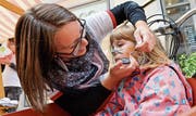 Das Kinderschminken ist eine willkommene Abwechslung zum Markttreiben.