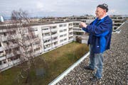 Günter Welte fotografiert vom Dach die Siedlung an der Reutistrasse, die neuen Mehrfamilienhäusern weichen soll. (Bild: Reto Martin)