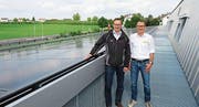 Christoph Strassmann, Leiter Markt und Kunden der TBW, und Andreas Dobler, Geschäftsführer des Sicherheitsverbundes, neben der über 860 Quadratmeter grossen Fotovoltaikanlage. (Bild: PD)