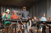 Busswiler Primarschüler und Musiker der Militärformation Spiel Heer Ost stehen gemeinsam auf der Bühne. (Bild: Christoph Heer)