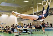 Mit viel Schwung zeigt das Mädchen ihre Übung an den Ringen vor. Die Punkterichter schauen genau hin. (Bild: Donato Caspari)