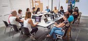 Im Austausch: Kurator Harm Lux und die Gruppe von 17 Künstlerinnen und Künstlern in der Shedhalle im Eisenwerk. (Bild: Reto Martin)