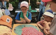Schnecken liefern sich ein Rennen, die Buben beobachten sie dabei. (Archivbild: pd)