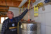 Ueli Senn kontrolliert ein Ventil der Abluftleitung, welche das CO2 aus den Gärtanks ins Freie leitet. (Bild: Hanspeter Thurnherr)