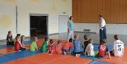 Aikido-Lehrer Alexander Nyaguy erklärt den Kindern mit Rebecca Hungerbühler die nächste Übung. (Bild: Miranda Diggelmann)