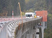 In luftiger Höhe verlegen Bauarbeiter mit Hilfe eines Rollgerüsts eine Wasserleitung. (Bild: Andy Lehmann)