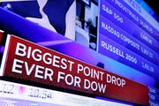 An einem Fernsehbildschirm in der New York Stock Exchange (NYSE) sind am Montag die Nachrichten über den Absturz des Dow-Jones-Indexes zu sehen – er verlor bis Handelsschluss so viel wie noch nie zuvor an einem Tag. (Bild: Keystone)