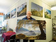 Werner Legler zeigt die Landschaftsbilder aus seinem neuen Kalender an einer Ausstellung im Seecafé in Buchs. (Bild: Hansruedi Rohrer)