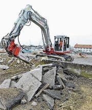 Ein Bagger entfernt die Mauer des Kiesplatzes. (Bild: Donato Caspari)