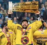 Martin Plüss stemmt den Meisterpokal in die Höhe – mittlerweile hat er seine Karriere beendet. (Bild: KEY)