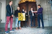 Initiant Roman Fischer (ganz rechts) überreicht Stadtschreiber Ralph Limoncelli im Rathaus-Eingangsbereich die Unterschriftenbogen. Mit von der Partie sind auch die Unterstützer Samuel Kienast, Lorenz Dünner und Franziska Schütz mit Linus. (Bild: Andrea Stalder)