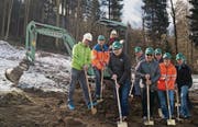 Ab sofort Baustelle: Gemeindepräsidentin Anna-Rita Dutly sitzt auf dem kleinen Bagger, vor ihr legen Vertreter der Bürgergemeinde, der Wasserkommission, der Planer und der Baufirmen Hand an. (Bild: Mathias Frei)