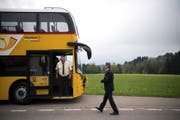 Buschauffeur Peter Bernegger (l.) und Walter Schwizer, Leiter Region Ostschweiz von PostAuto, nehmen das neue Fahrzeug in Augenschein. (Bild: GIAN EHRENZELLER (KEYSTONE))