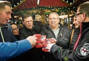 Glühwein-könig Hanspeter Maier (hinten rechts) stösst vor seinem Stand mit Gästen an. (Bild: Thi My Lien Nguyen)