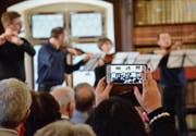 Eine Konzertbesucherin hält eine Momentaufnahme auf ihrem Smartphone fest. (Bild: Christoph Heer)