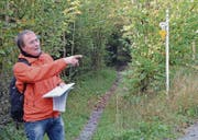 Kantonsarchäologe Hansjörg Brem zeigt beim Kaabrüggli in Tägerschen den Verlauf des historischen Verkehrswegs. (Bild: PD/Markus Zahnd)
