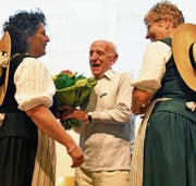 Veteran Willi Sonderegger mit Jahrgang 1921 wird von den Ehrendamen mit Blumen und einem Glas Honig beschenkt. (Bild: Fritz Heinze)