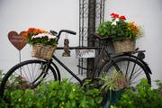 Ein mit Blumen dekoriertes Velo, daneben ein rostiges Herz. (Bild: Urs Jaudas)