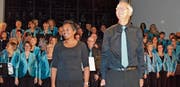 Dirigentin Jeannine Egli, Gesamtleiter Walter Gysel und der Chor nehmen den Applaus nach dem Konzert entgegen. (Bild: Sereina Meienhofer)