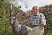 Peter Diener mit seiner Steinbockskulptur, welche beim Eingang zu seinem Haus steht. (Bild: Adi Lippuner)