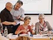 Die Formulierung eines Antrags fordert heraus: Kirchenratspräsident Koni Bruderer und Kirchenrat Thomas Gugger halten die Köpfe zusammen. Synodal-Vizepräsidentin Sibylle Blumer-Stähelin und Präsidentin Heidi Steffen-Kern diskutieren derweil mit den Synodalen weiter. (Bilder: Roger Fuchs)