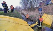 Feuerwehrmann Florian Eugster steht mehr als knietief im Wasser, während es Ruedi Jungen hinter der Sperre nur bis zu den Knöcheln reicht. (Bild: Manuel Nagel)